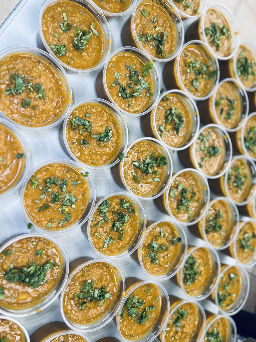 Portioned curry cups, garnished