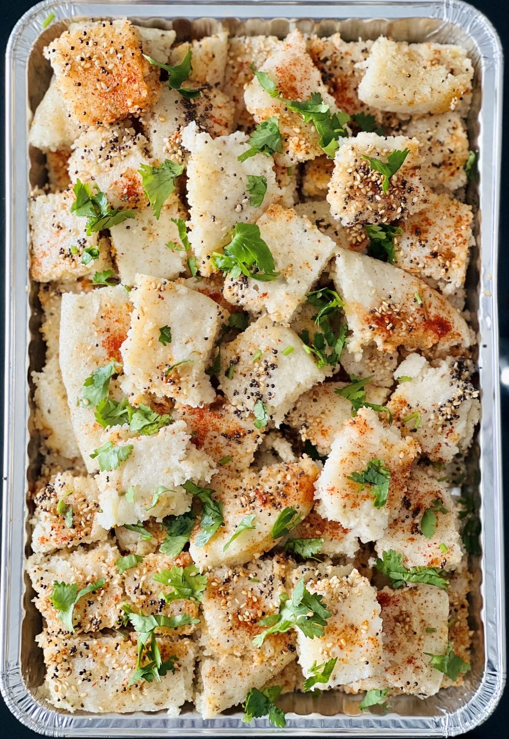 A full tray of freshly tempered dhokla