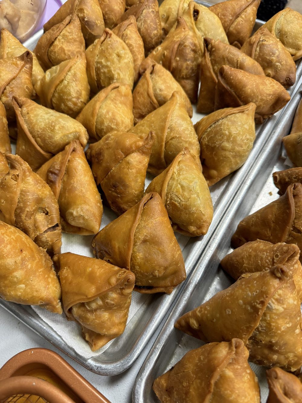 A large batch of samosas, just cooked