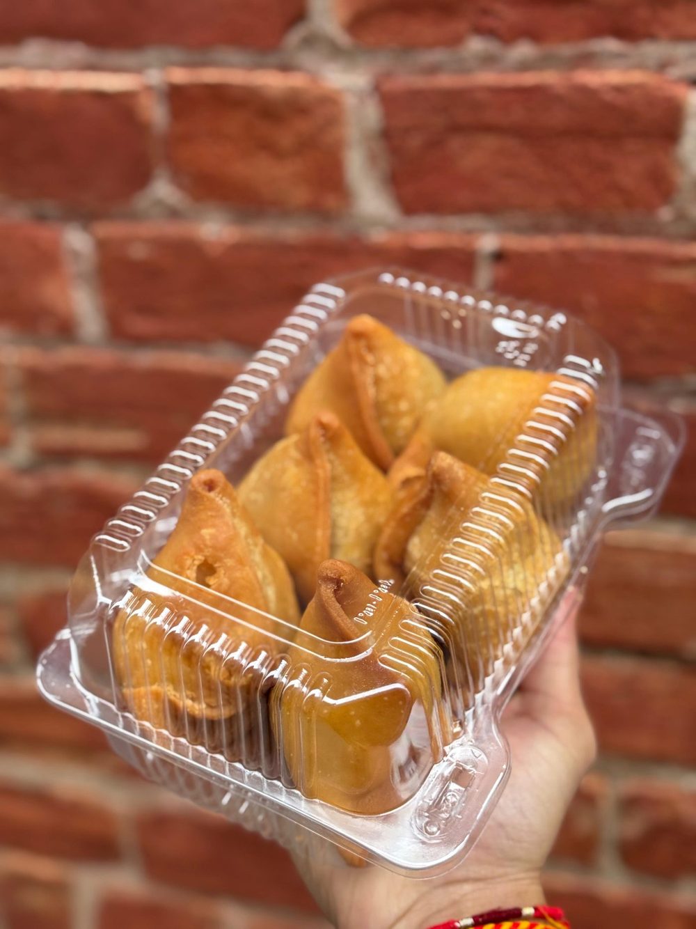 A takeaway box of samosas and fafda